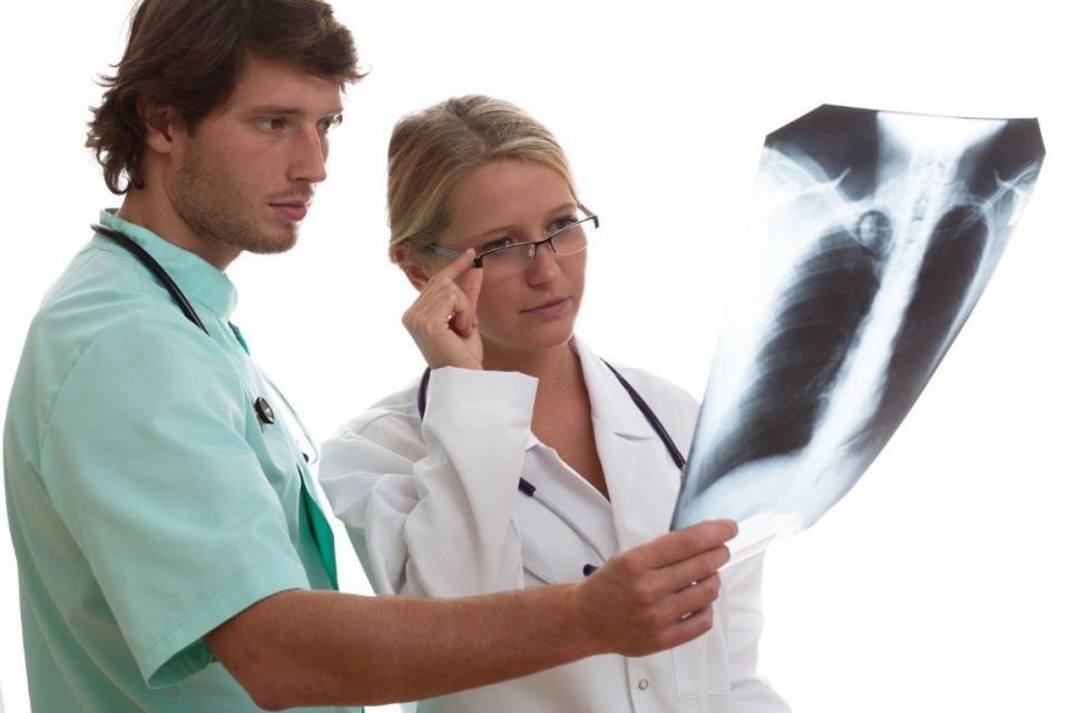 Medico e radiologo che vedeno la radiografia di una schiena.
