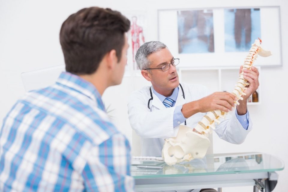 Medico che spiega a un paziente i dolori vertebrali